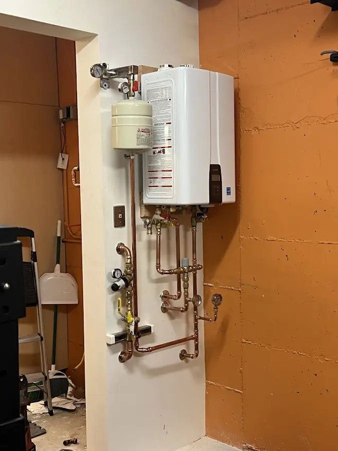 Plumbing technician inspecting water heater connections in Bay Minette